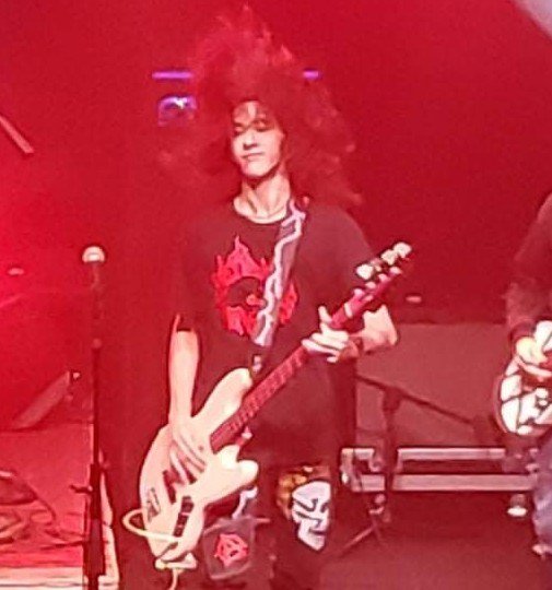 Milo Powers performing live under red lights