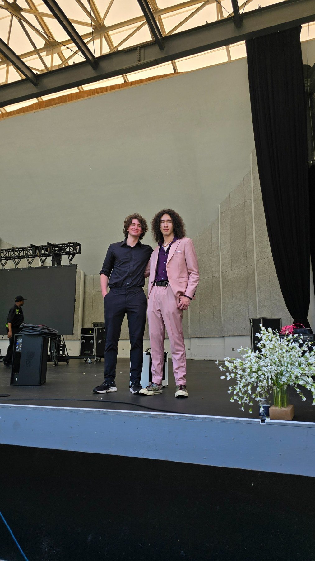 Milo Powers standing on stage in a suit